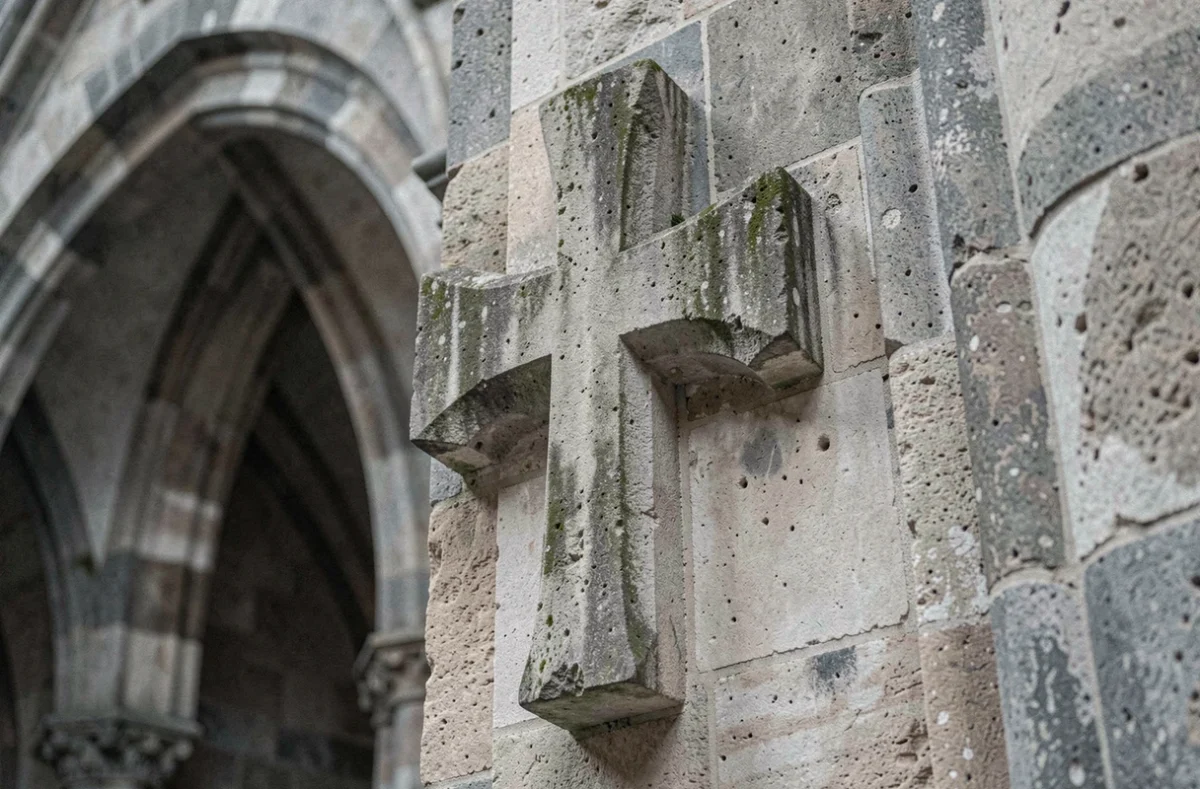 Croix de Lorraine sculptée en pierre ancienne sur un mur de cathédrale médiévale gothique