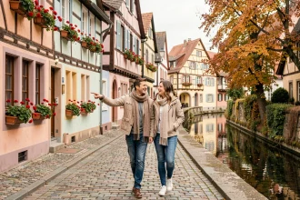 Couple en promenade dans un village alsacien pittoresque avec maisons à colombages colorées, sortie pas chère en Alsace