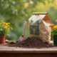 Sac de terreau abordable sur une table en bois avec outils et plantes en fleurs